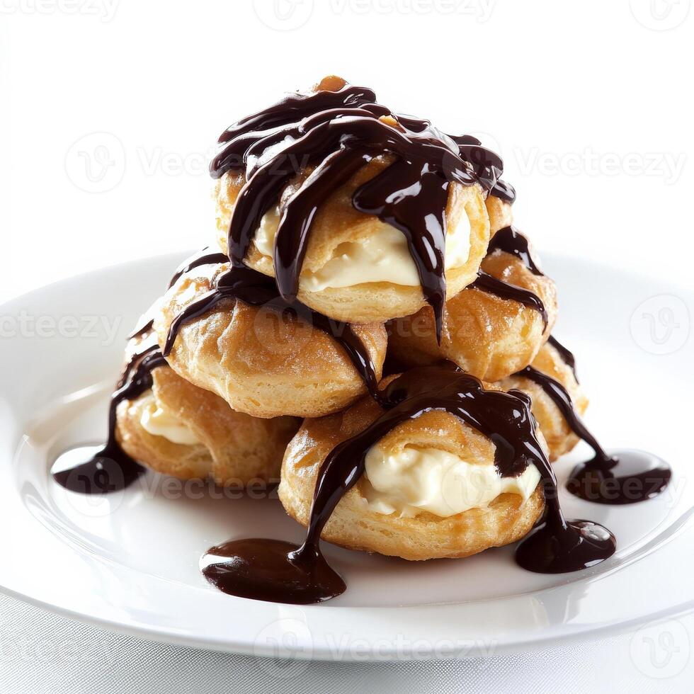 A close-up of a profiterole au chocolat, a cream puff filled with vanilla pastry cream and topped with chocolate sauce, arranged in a stack on a plate, showcasing the light and airy pastry and the photo