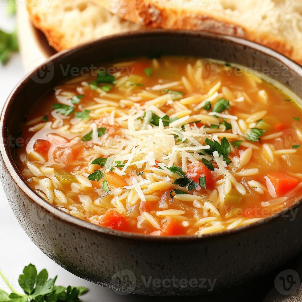 A close-up of a warm and comforting orzo soup, a hearty Italian soup with orzo pasta, vegetables, and chicken broth, simmered until thick and flavorful, garnished with grated parmesan cheese and fresh photo