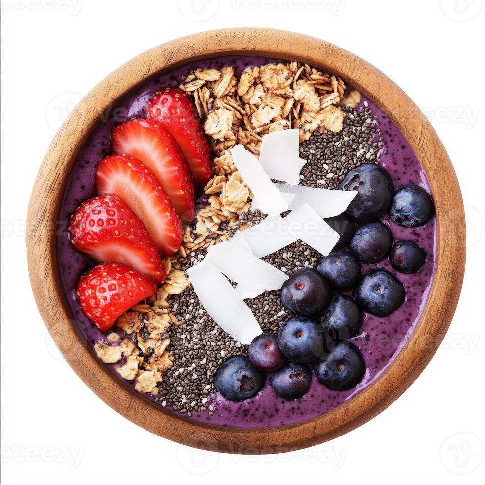 A bowl of vibrant acai smoothie topped with granola, fresh berries, coconut flakes, and chia seeds, served in a wooden bowl. A healthy superfood breakfast. Isolated on clean white background photo