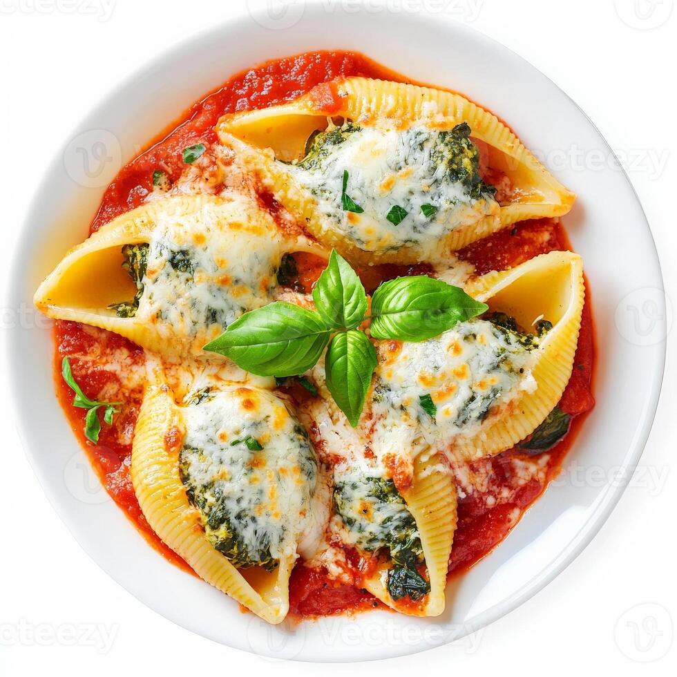 A warm plate of cheesy spinach and ricotta stuffed shells, baked in marinara sauce, topped with melted mozzarella and fresh basil. An Italian comfort dish. Isolated on clean white background photo