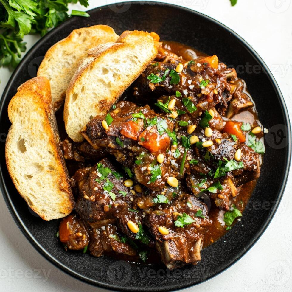 A plate of braised oxtail alla vaccinara, featuring tender pieces of oxtail meat, braised slowly in a rich and flavorful tomato sauce with celery, onions, garlic, carrots, red wine, chocolate, and photo