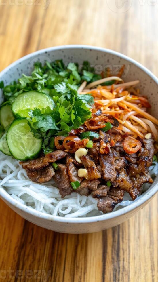 Close-up of Vietnamese rice noodle bowl with grilled beef, vegetables, herbs. Food photography photo