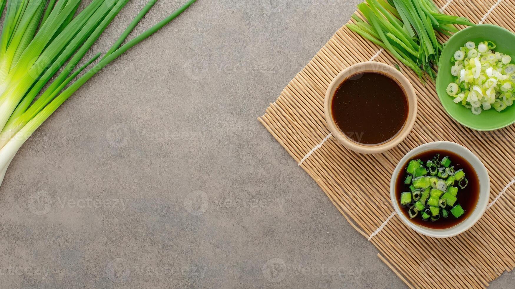 Fresh scallions and soy sauce on a bamboo mat, background for cooking photo