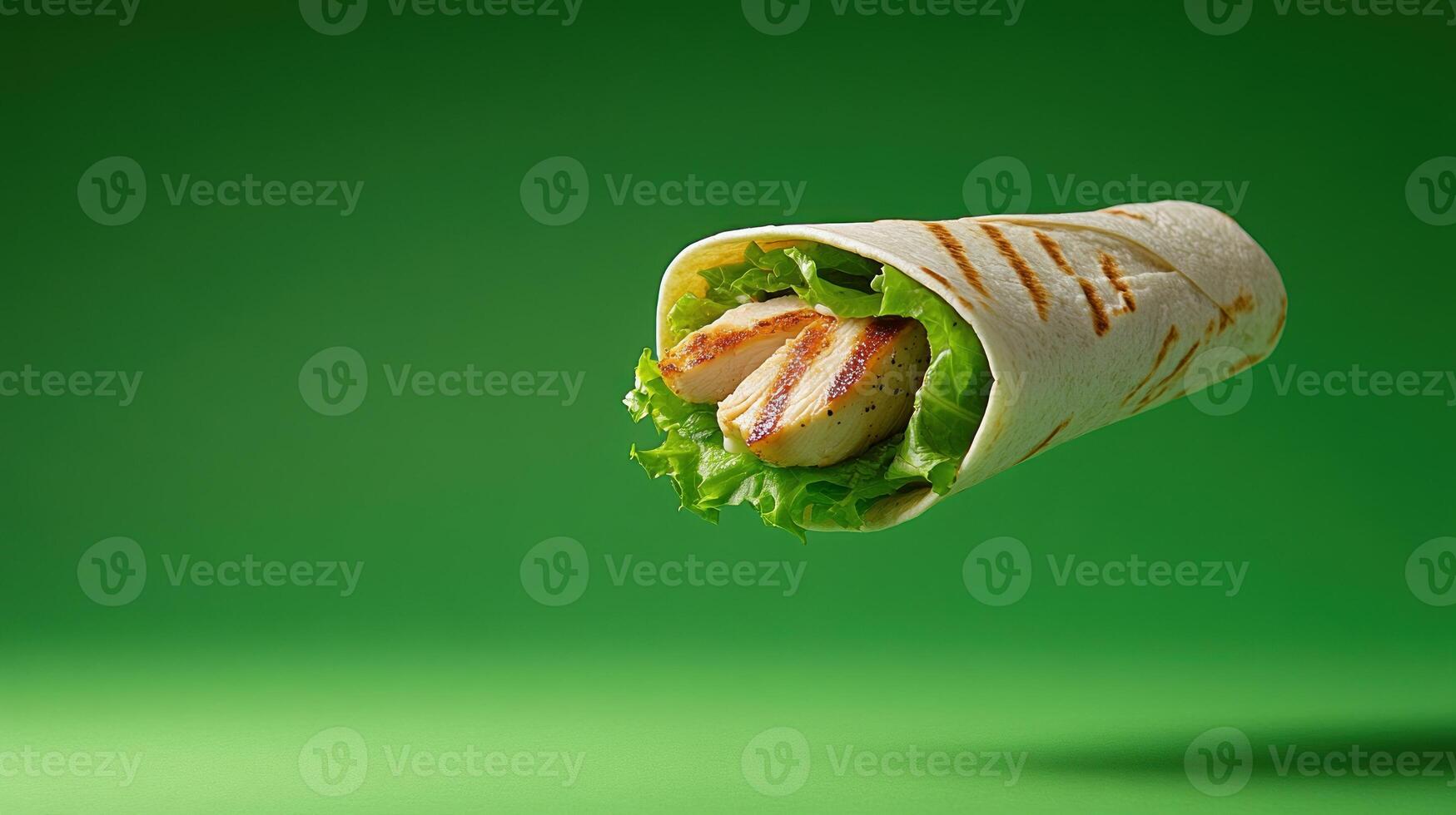 Grilled chicken wrap with fresh greens floating against green background. For menu promotions photo
