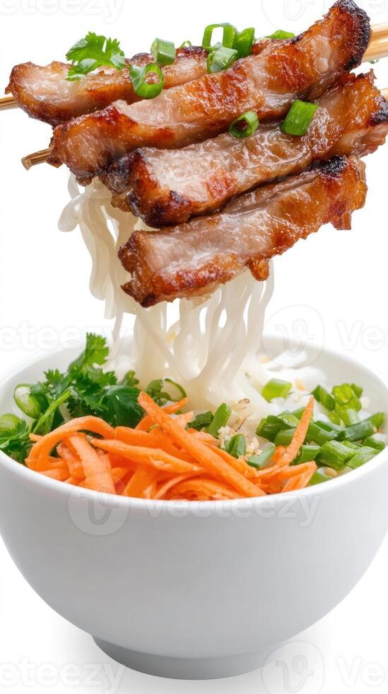 Grilled pork skewers over noodles, carrots, and greens in a white bowl on a white background photo