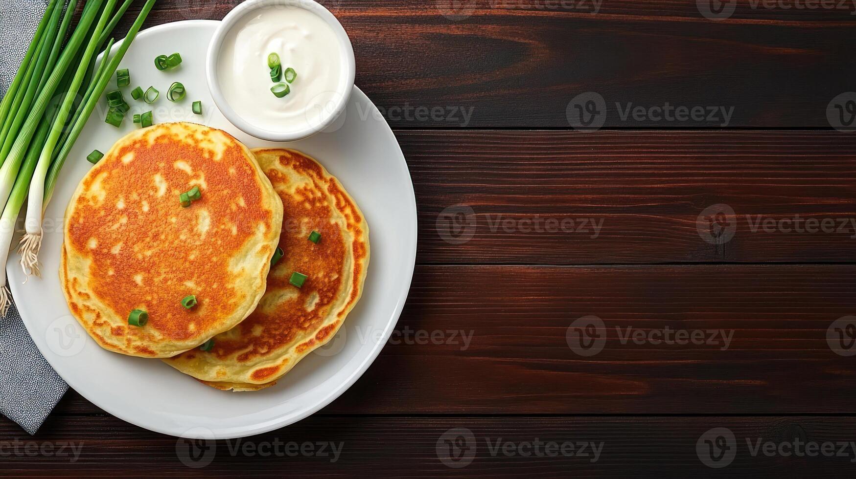 Pancakes with sour cream and green onions, top view. Food photography and cooking recipe photo