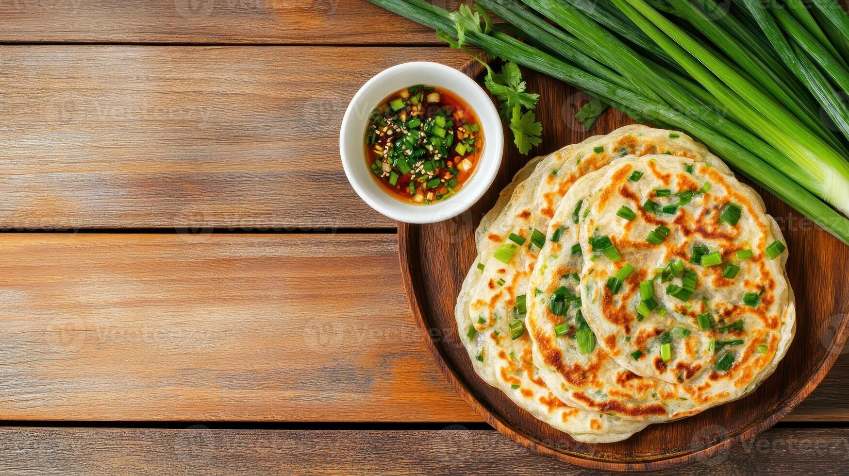 Scallion pancake on plate with sauce on wood table, background in light, for menu image use photo