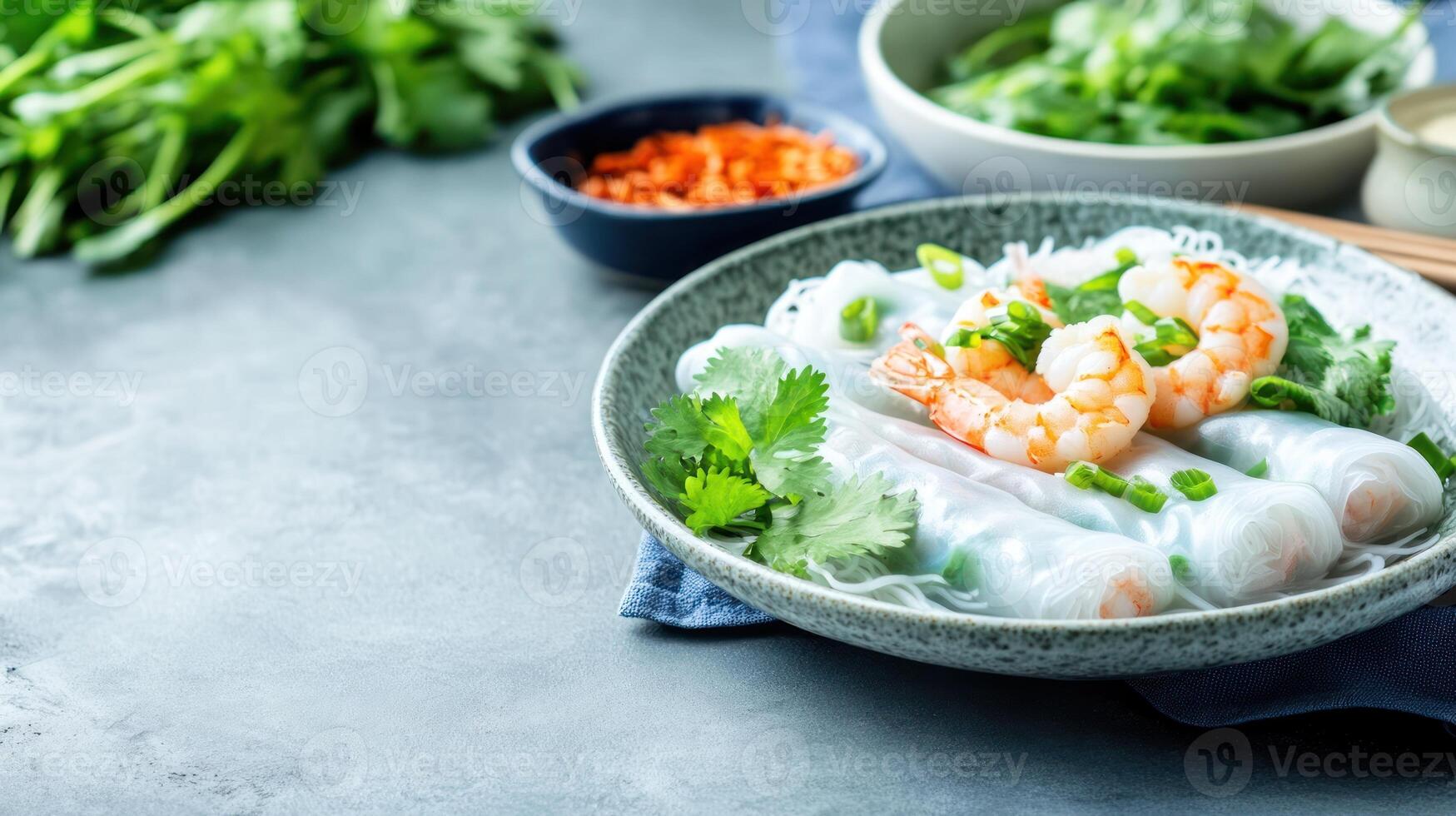 Shrimp spring rolls displayed in gray scene ready for commercial use. Fresh herbs in background photo