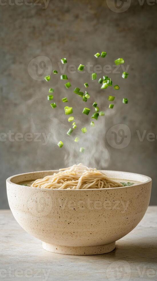 Steaming noodle soup in a bowl with flying herbs, neutral background. Food photography, recipe photo