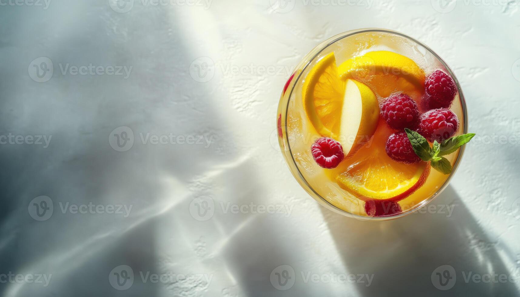 Refreshing Summer White Sangria With A Medley Of Fruits And Berries, Infused With Apple, Lemon, Oranges, And Raspberry. Light Concrete Table With Ample Space For Copy photo