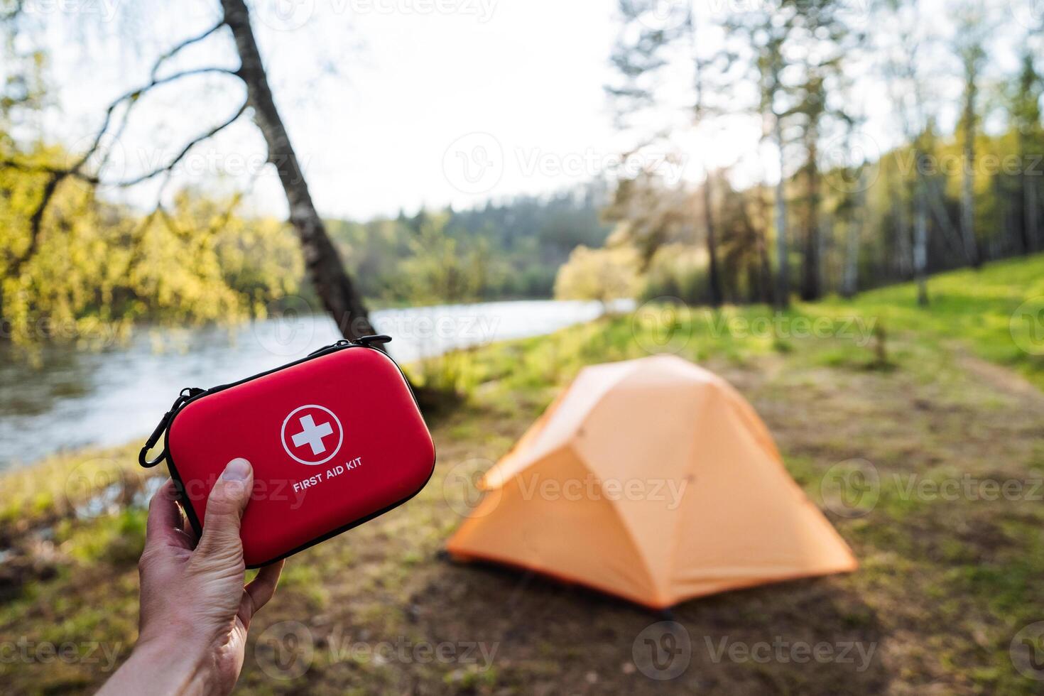 When embarking on an exciting adventure, it is essential to pack the right gear, particularly a solid first aid kit and a durable tent set up by the scenic river to ensure both safety and tranquility photo
