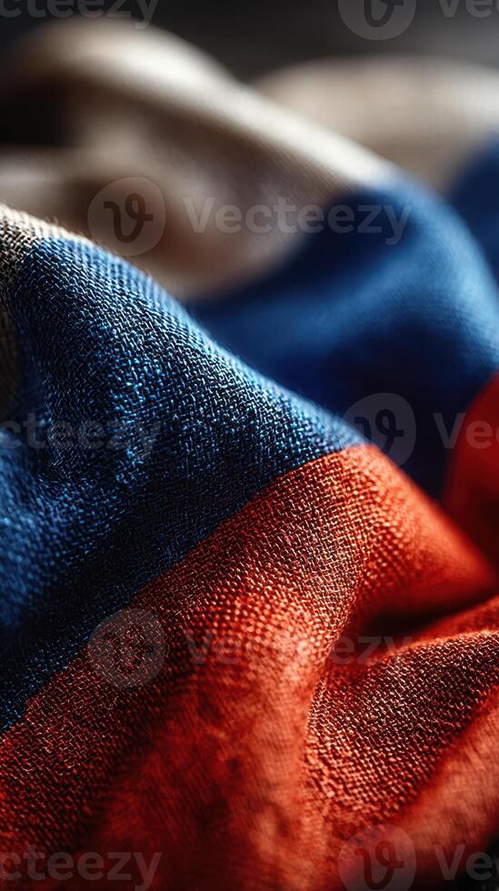 Fabric close-up shows detailed texture and vibrant colors of a flag in rich hues of blue, white, and red under soft lighting photo