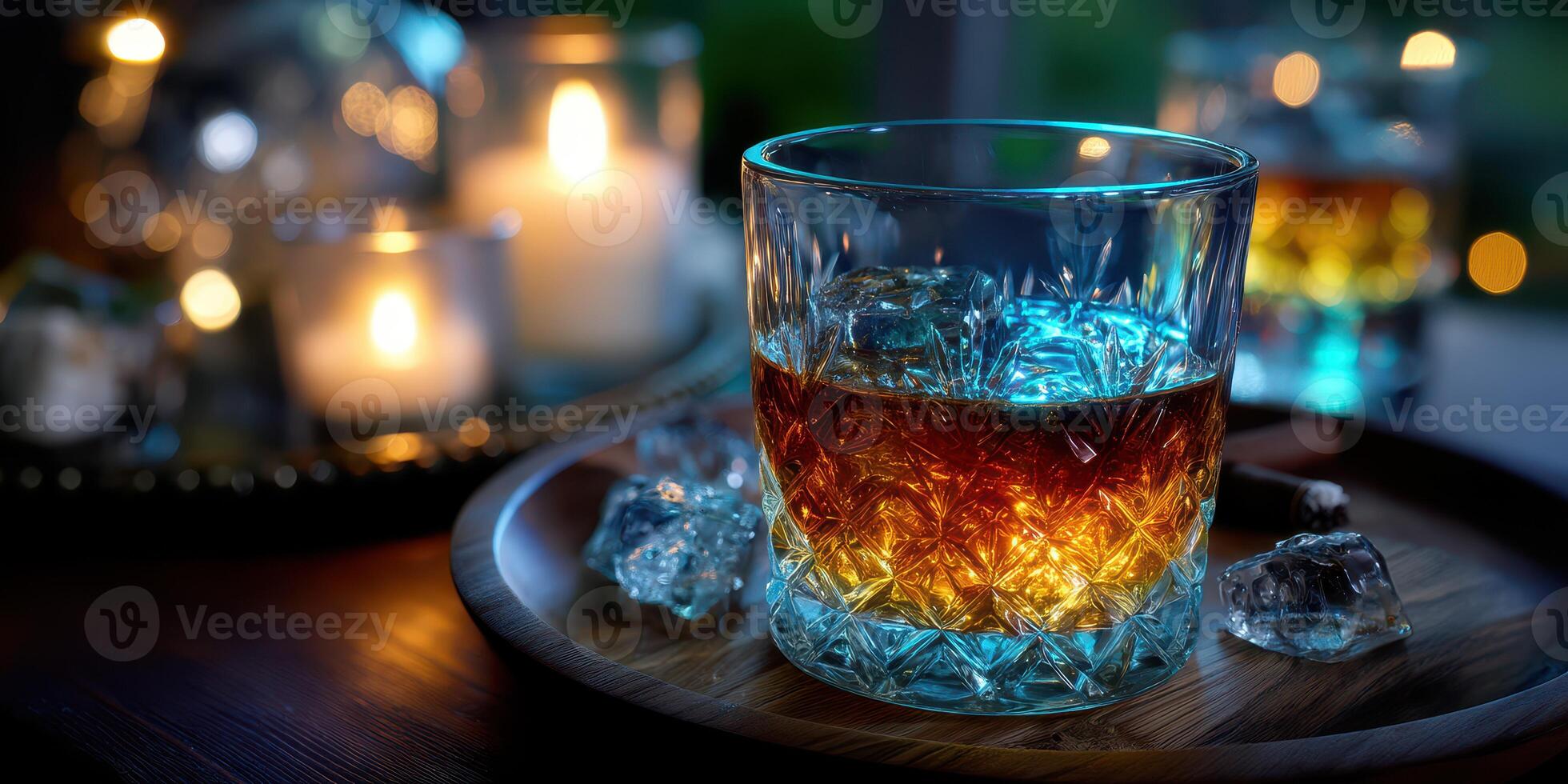 Whiskey served in a crystal glass with ice and candles illuminating the background at a cozy setting photo