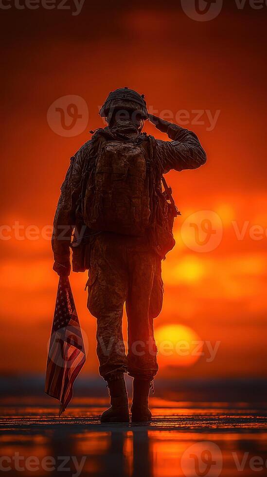 Soldier saluting at sunset holding American flag in dramatic orange sky photo