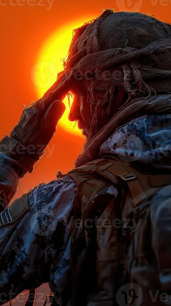 Soldier saluting against a dramatic sunset backdrop during a military operation photo