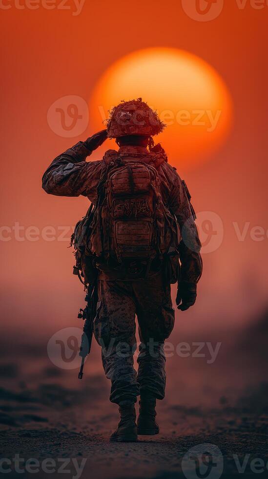 Soldier saluting at sunset during military operation in a desert landscape photo