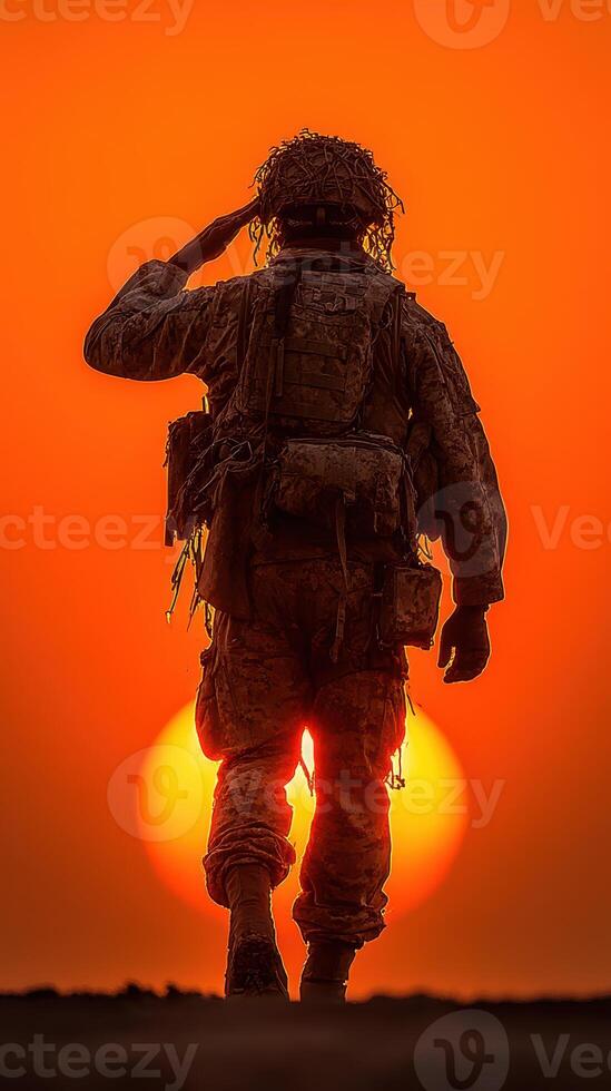 Soldier saluting at sunset in a distant landscape representing honor and bravery photo