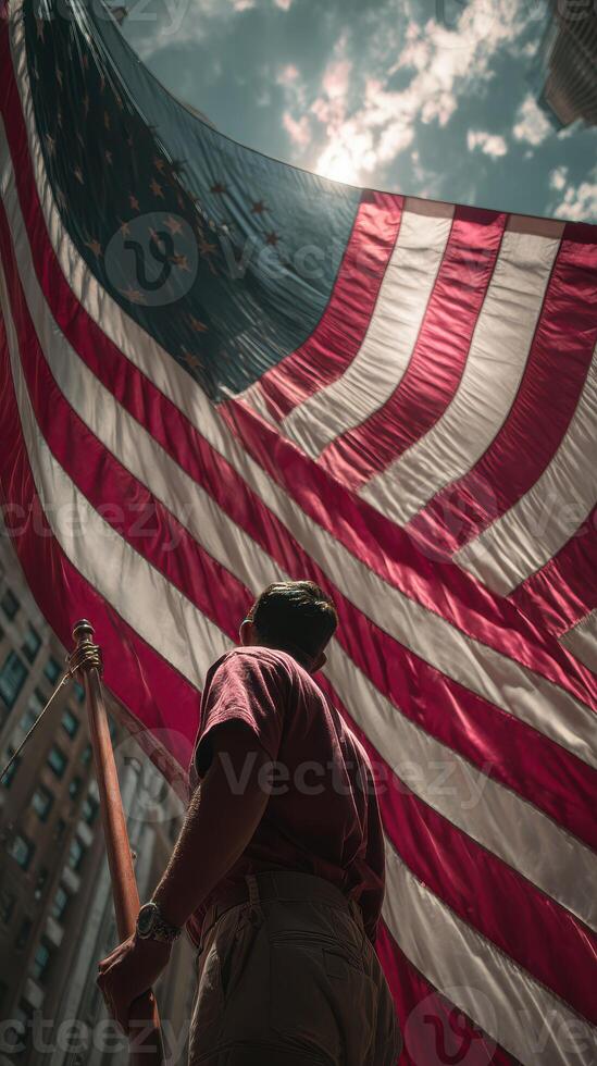 Person displaying large American flag against bright sky in urban setting during daytime photo