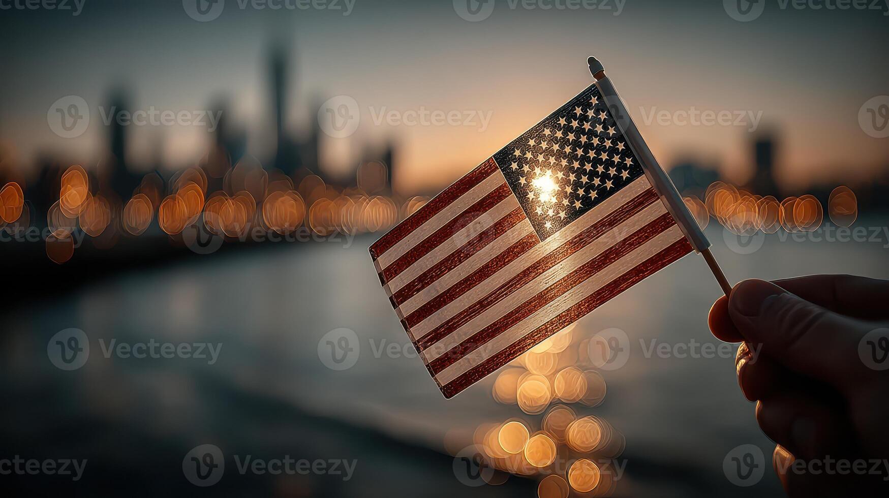 Waving a small American flag at sunset with a city skyline in the background photo