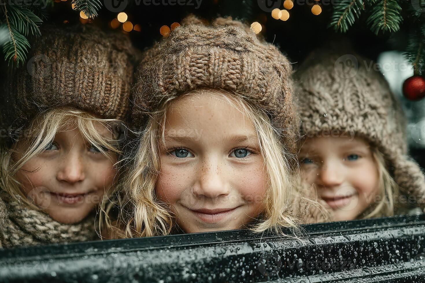 Three children with bright eyes enjoying winter festivities from behind a festive display in a cozy atmosphere photo