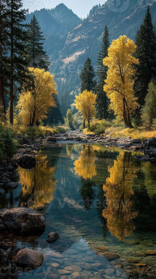 Tranquil autumn landscape with golden trees reflecting in a calm river surrounded by mountains photo