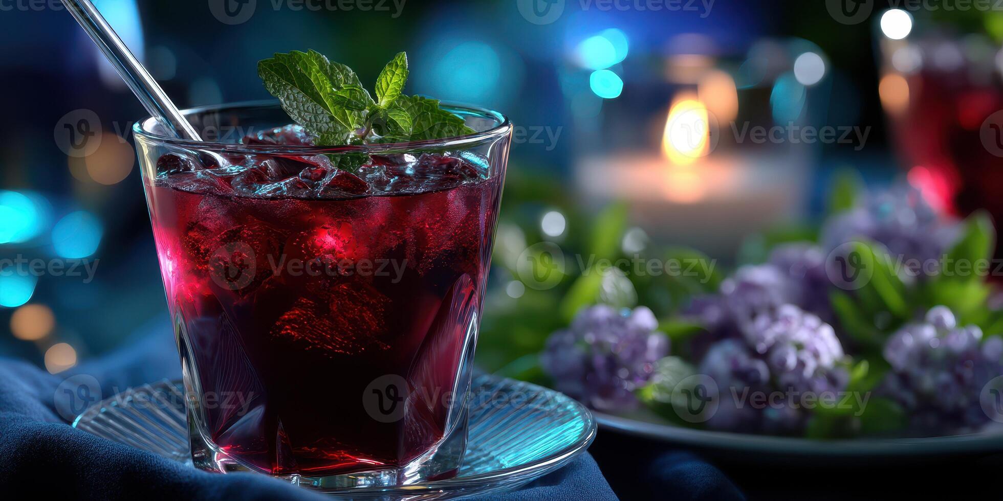 Refreshing berry drink garnished with mint on a blue table with candles and flowers during evening gathering photo