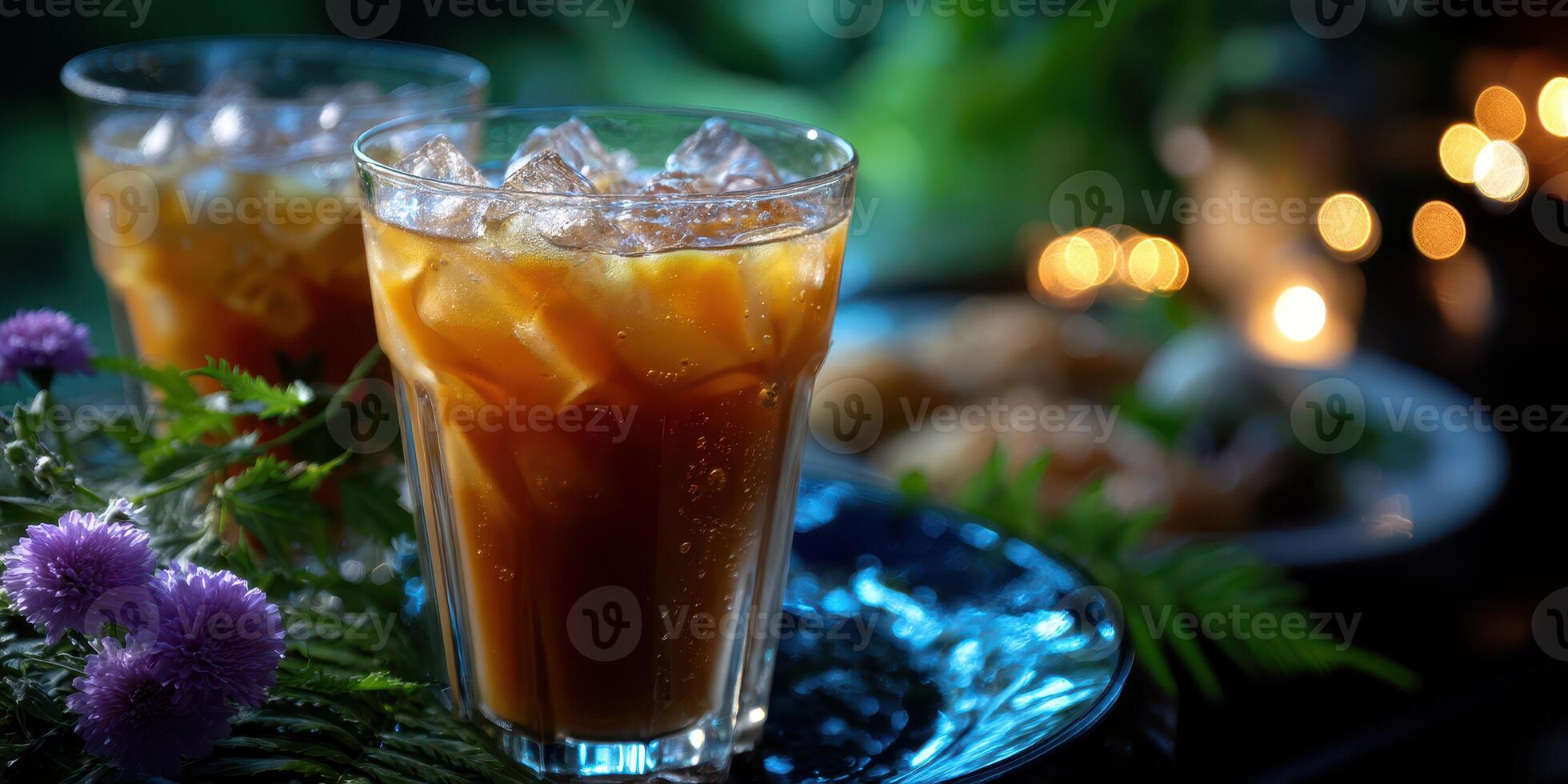 Refreshing iced beverages served on a decorative tray with flowers and warm lighting in a cozy outdoor setting photo