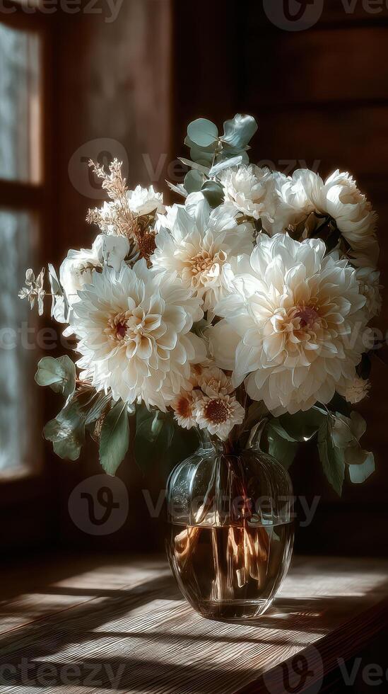 Floral arrangement in glass vase with soft lighting showcasing white and cream flowers in a cozy indoor setting during afternoon photo