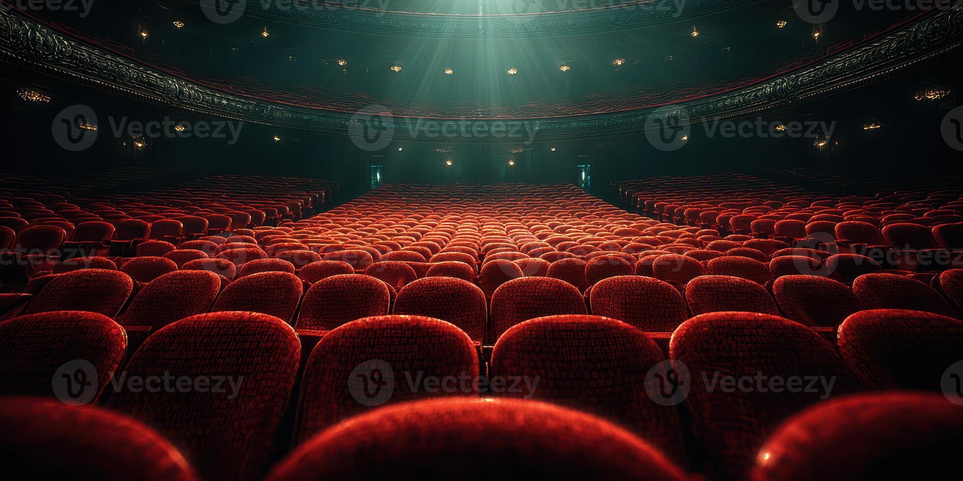 Rows of red velvet seats illuminate under soft spotlight in an empty theater before a performance begins photo