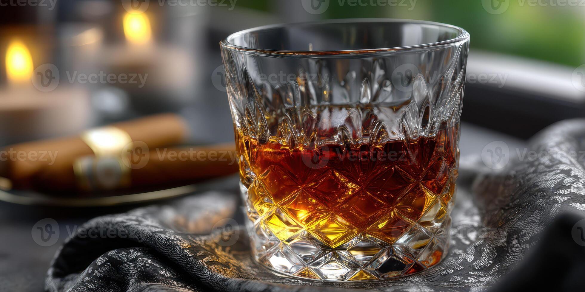 Elegant whiskey glass with rich amber liquid surrounded by candles and cigars in a cozy setting photo