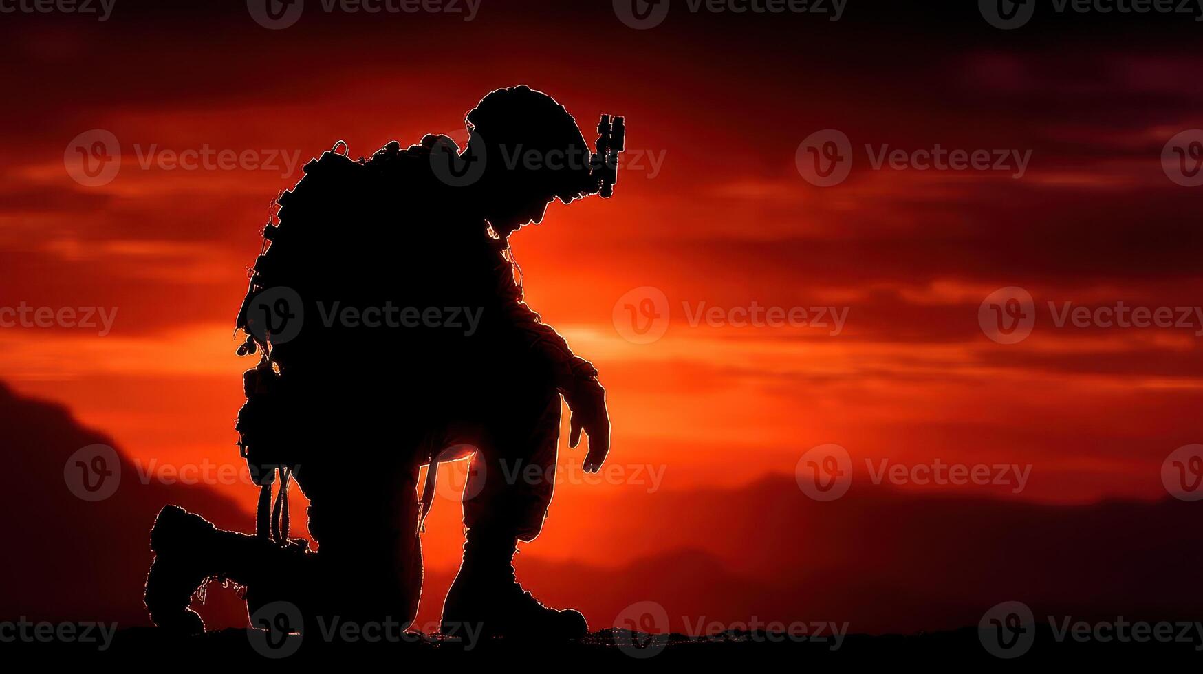 Soldier kneeling in silhouette during sunset in a mountainous terrain reflecting dedication and quiet reflection photo