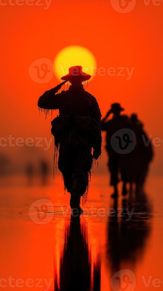 Soldiers saluting at sunset creating a striking silhouette against vibrant orange hues photo