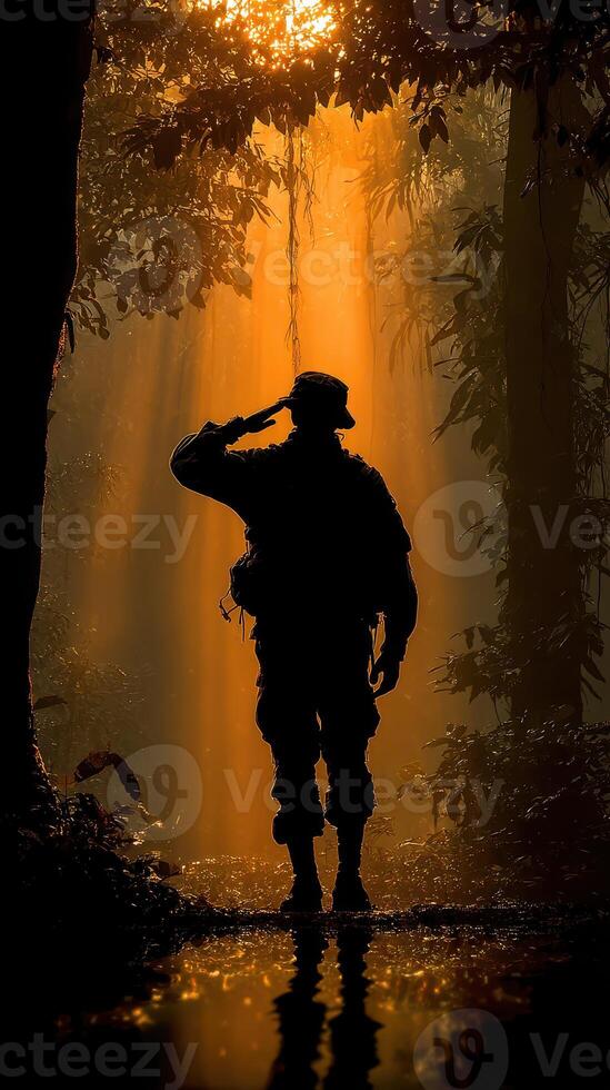 Soldier saluting in silhouette during sunrise amidst tropical forest setting photo