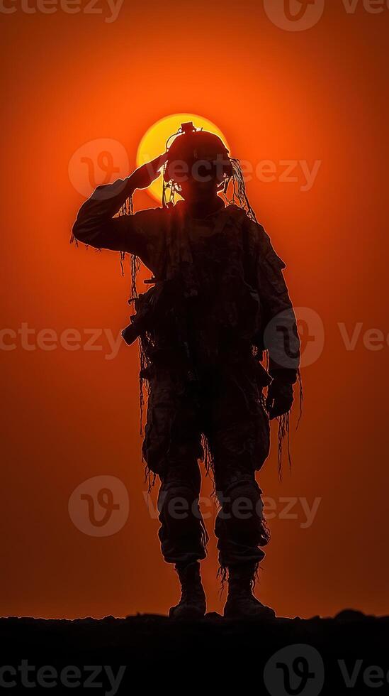 Soldier saluting against vibrant sunset backdrop in a desert landscape during evening hours photo