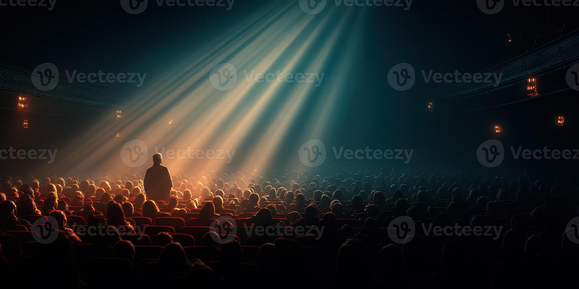Crowd watching performance in a theater with beams of light shining down from above photo