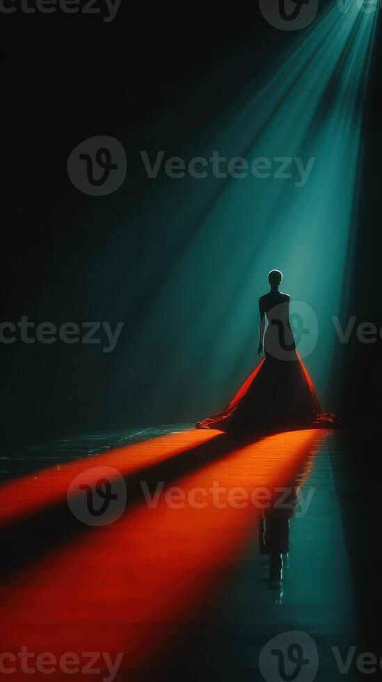 Elegant model in captivating black gown illuminated by dramatic spotlight during fashion show at night photo