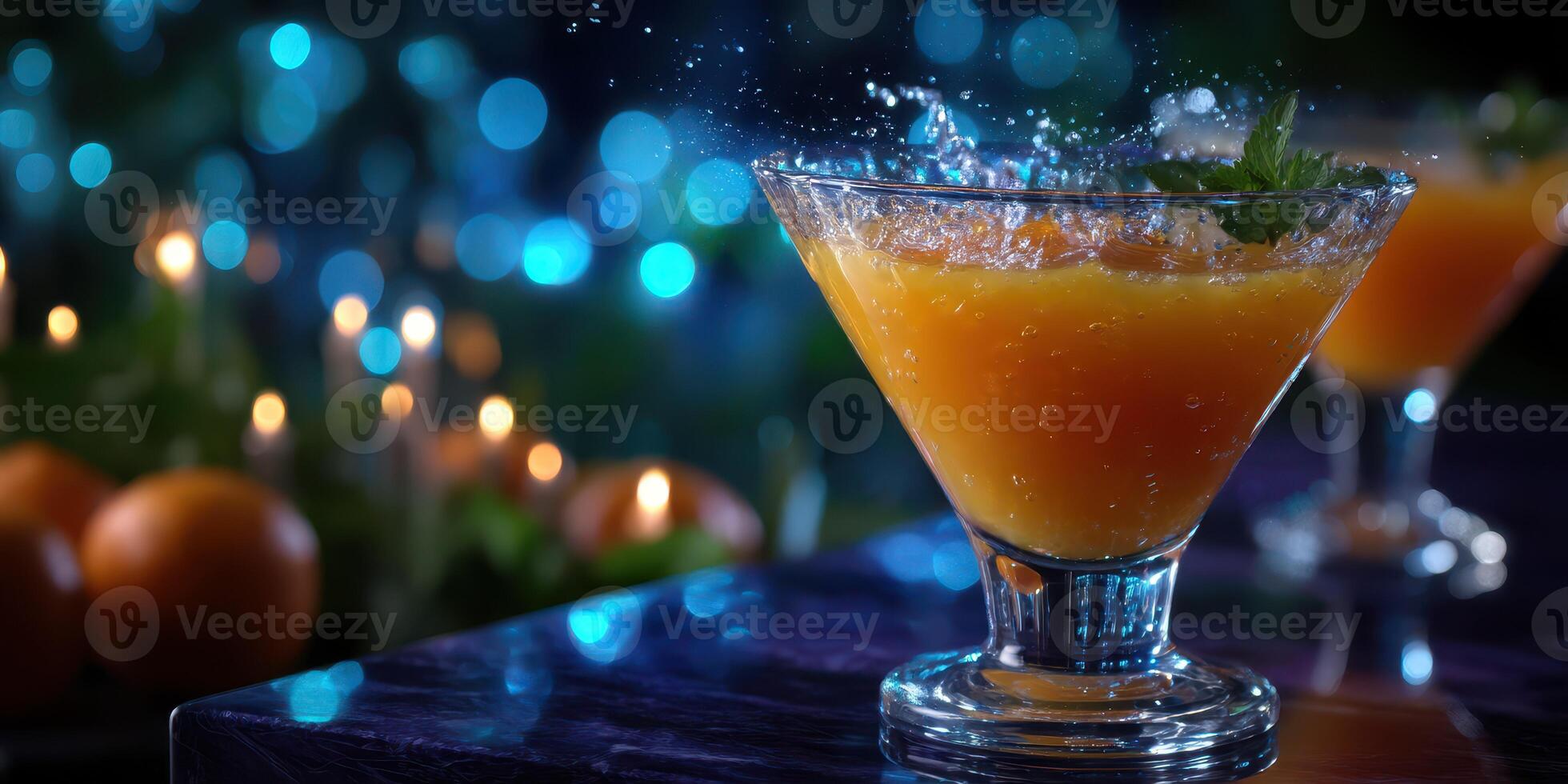 Bright orange cocktail splashes in a glass surrounded by festive decorations at an evening gathering photo