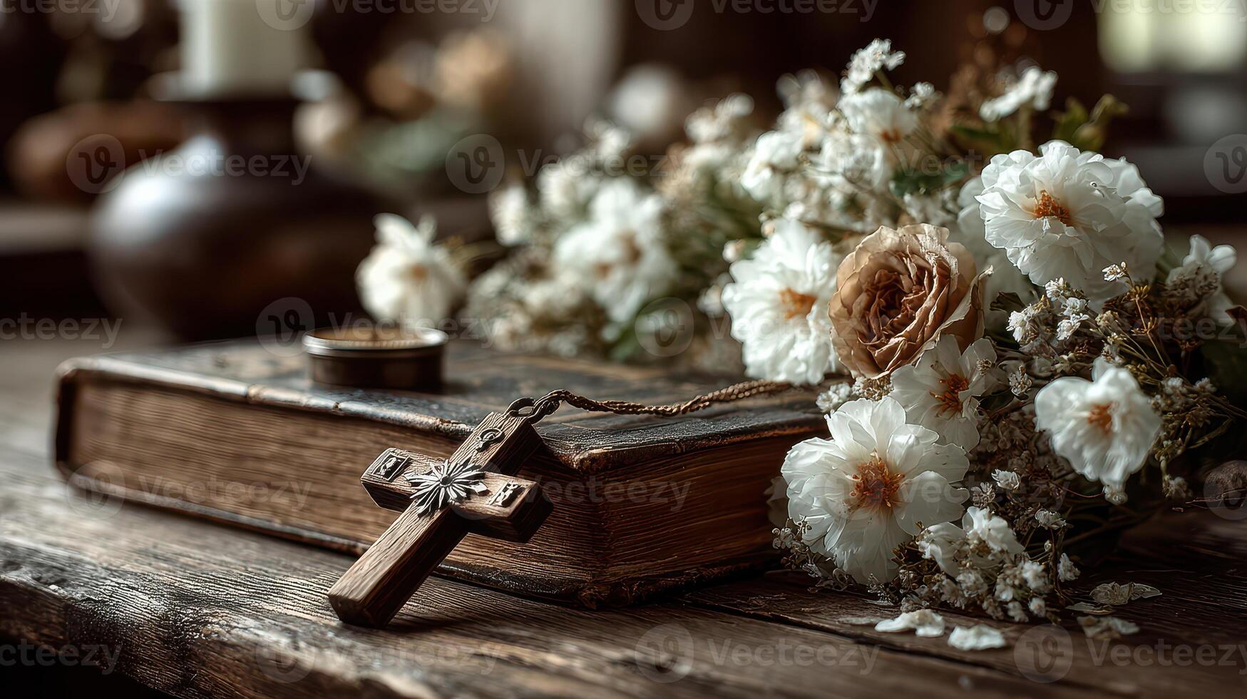 Antique book with wooden cross and bouquet of dried flowers on rustic table photo