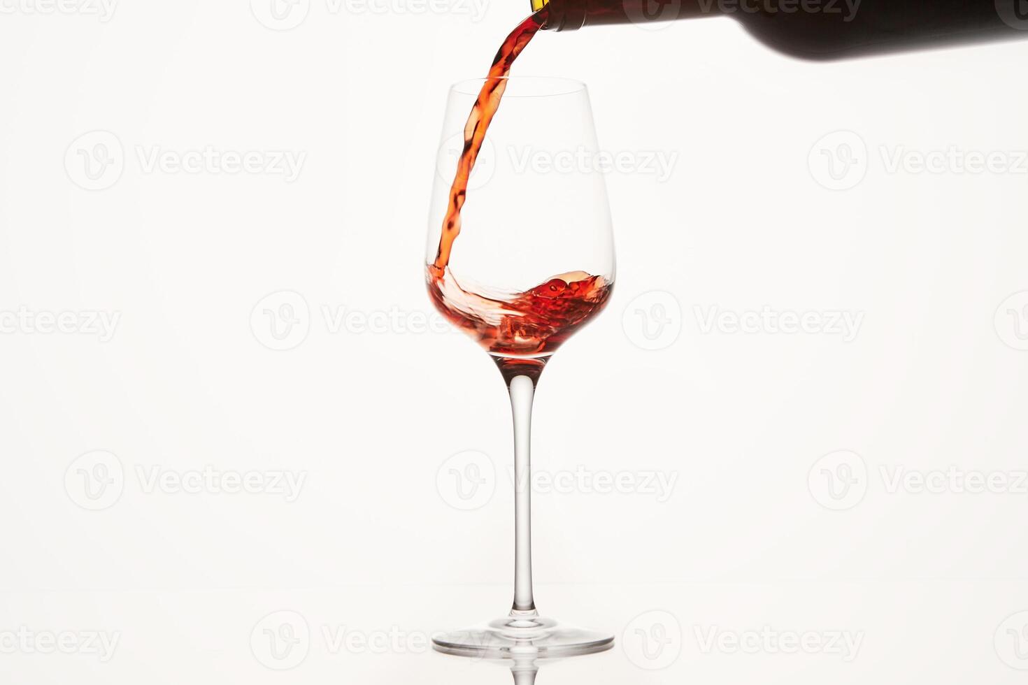 Red wine stream flows, swirls in glassware bowl. photo