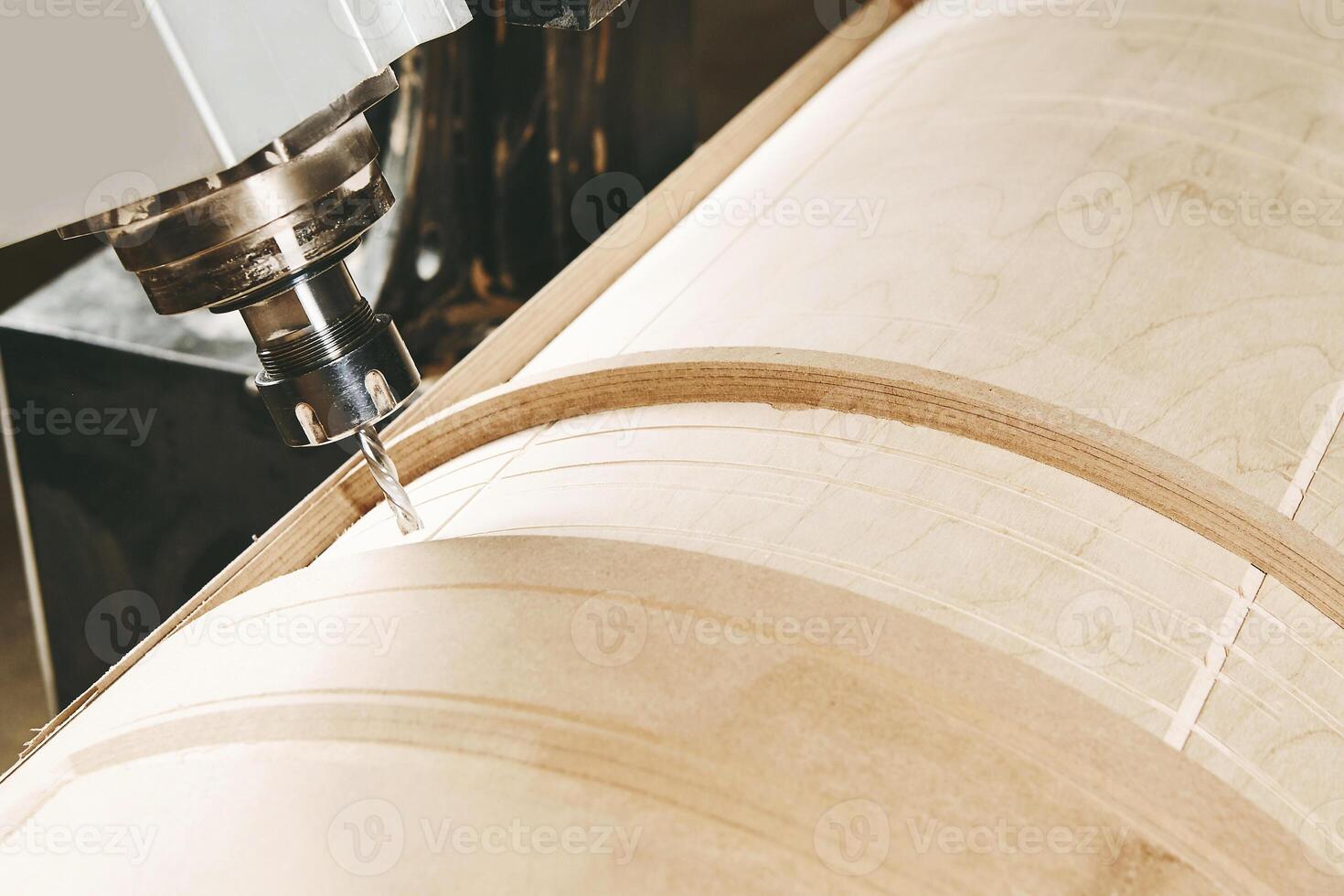 a four-axis numerically controlled woodworking machine cuts out complex lines on the canvas. CNC, computer control. photo