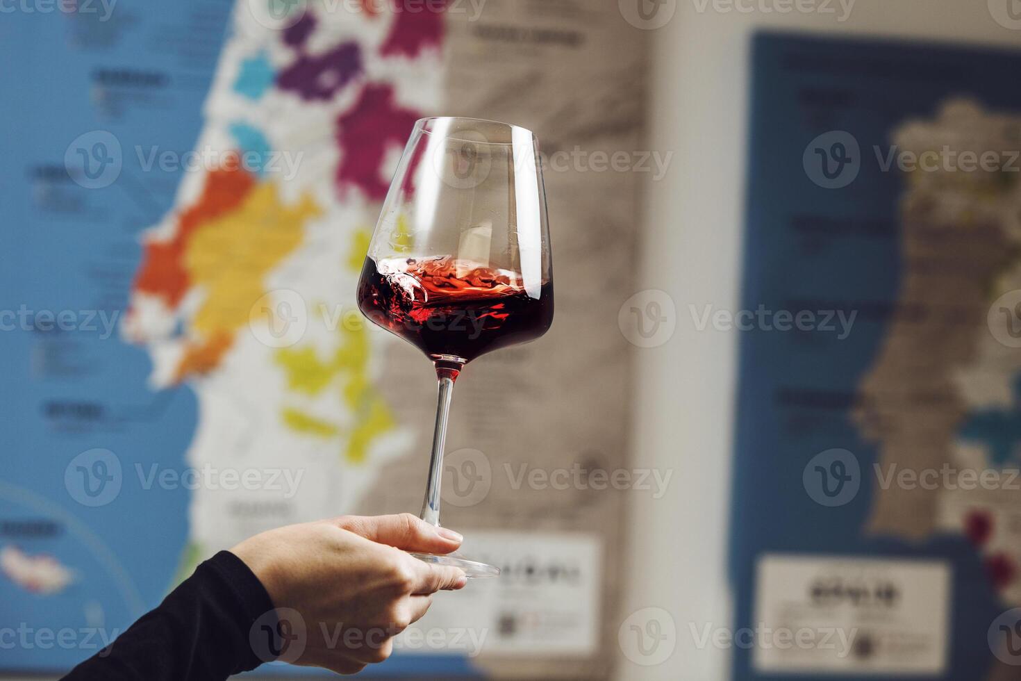 Sommelier Examining Red Wine Color and Clarity Against Map of Wine Regions photo