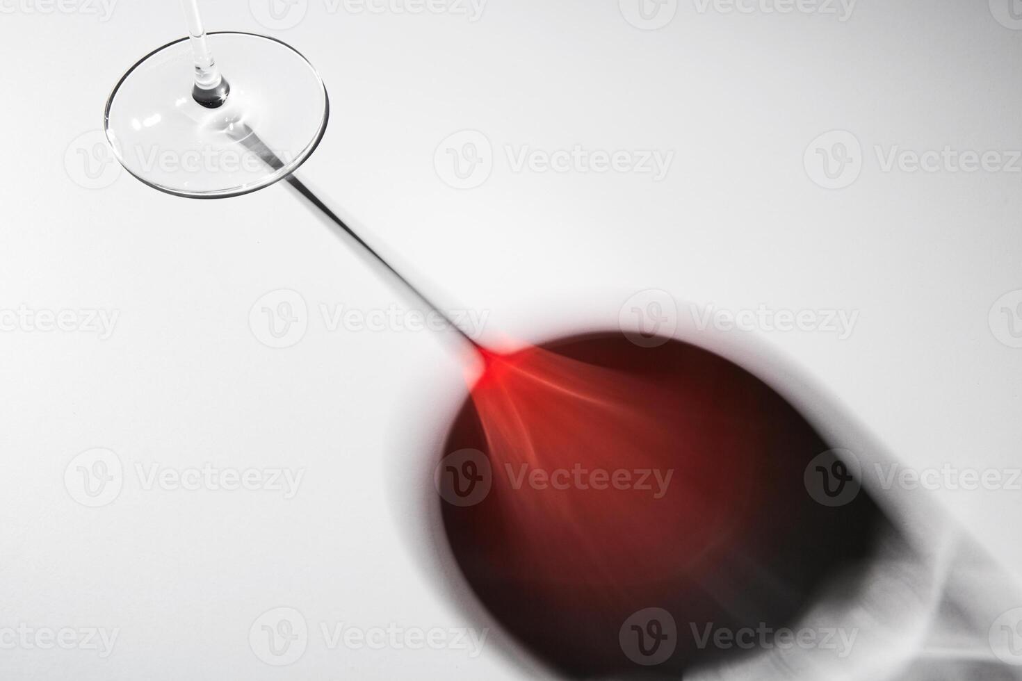 Black and red reflection of wineglass on thin stem. photo