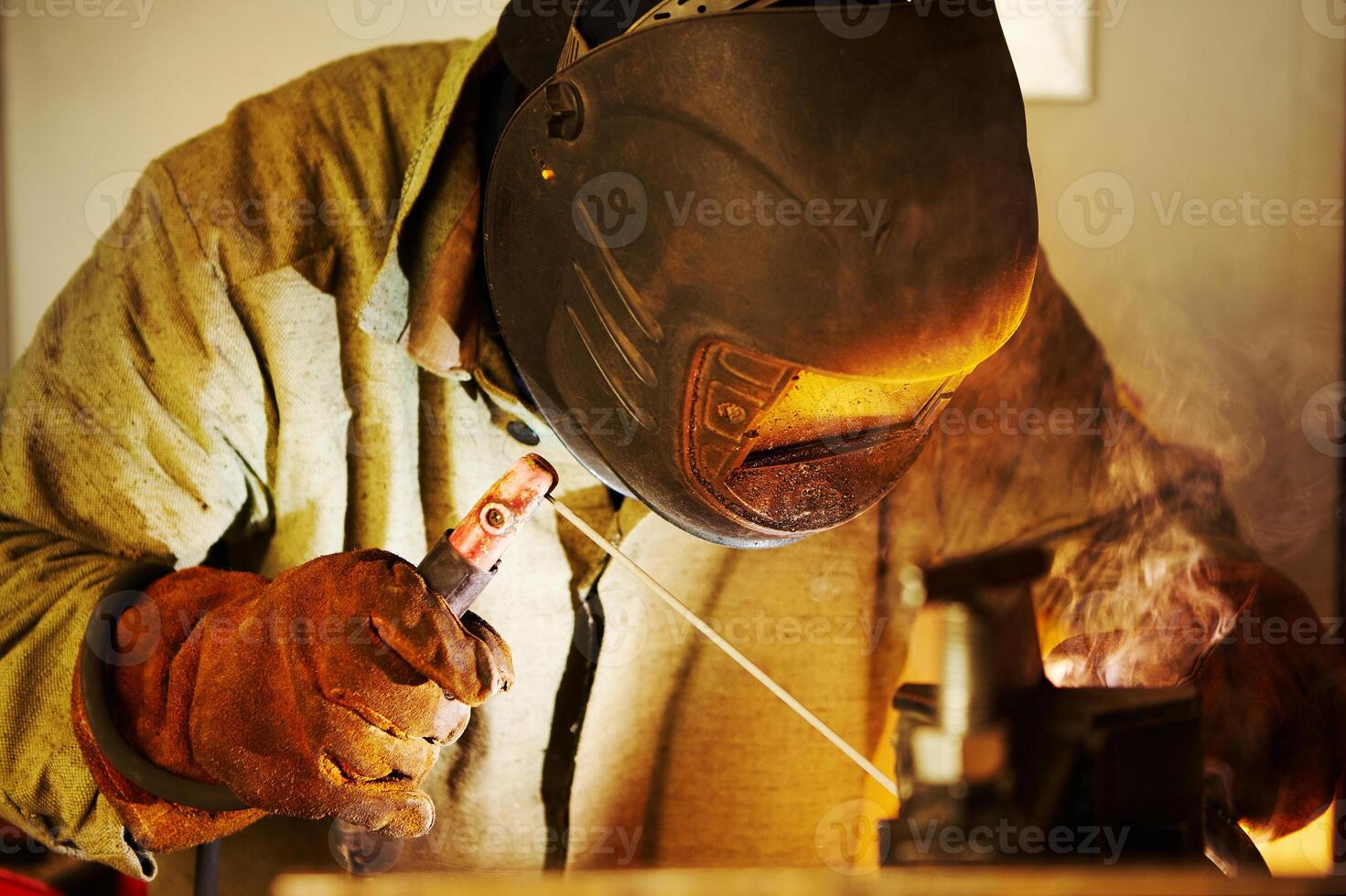 Close-up image of industrial worker at the factory welding. photo