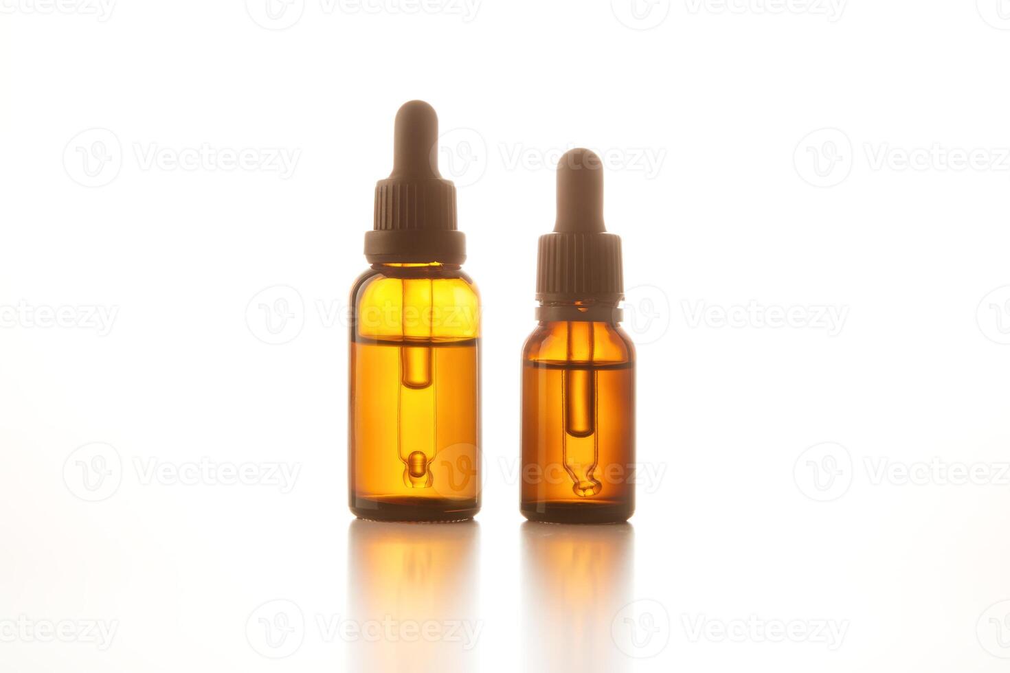 Two brown vials with black dropper caps isolated on white. photo