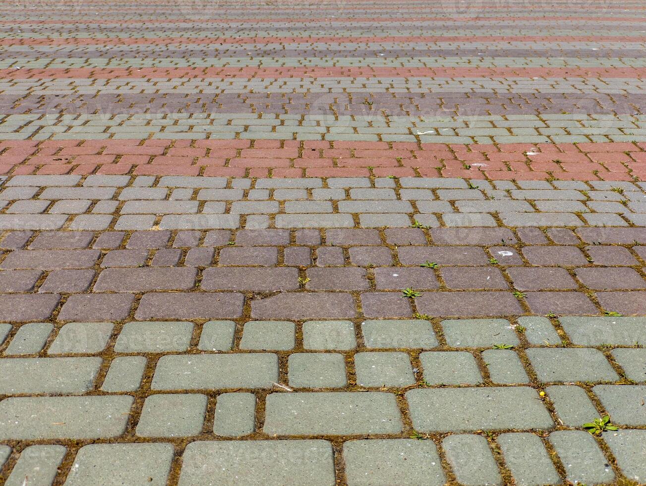 A brick walkway with a red and gray brick pattern photo