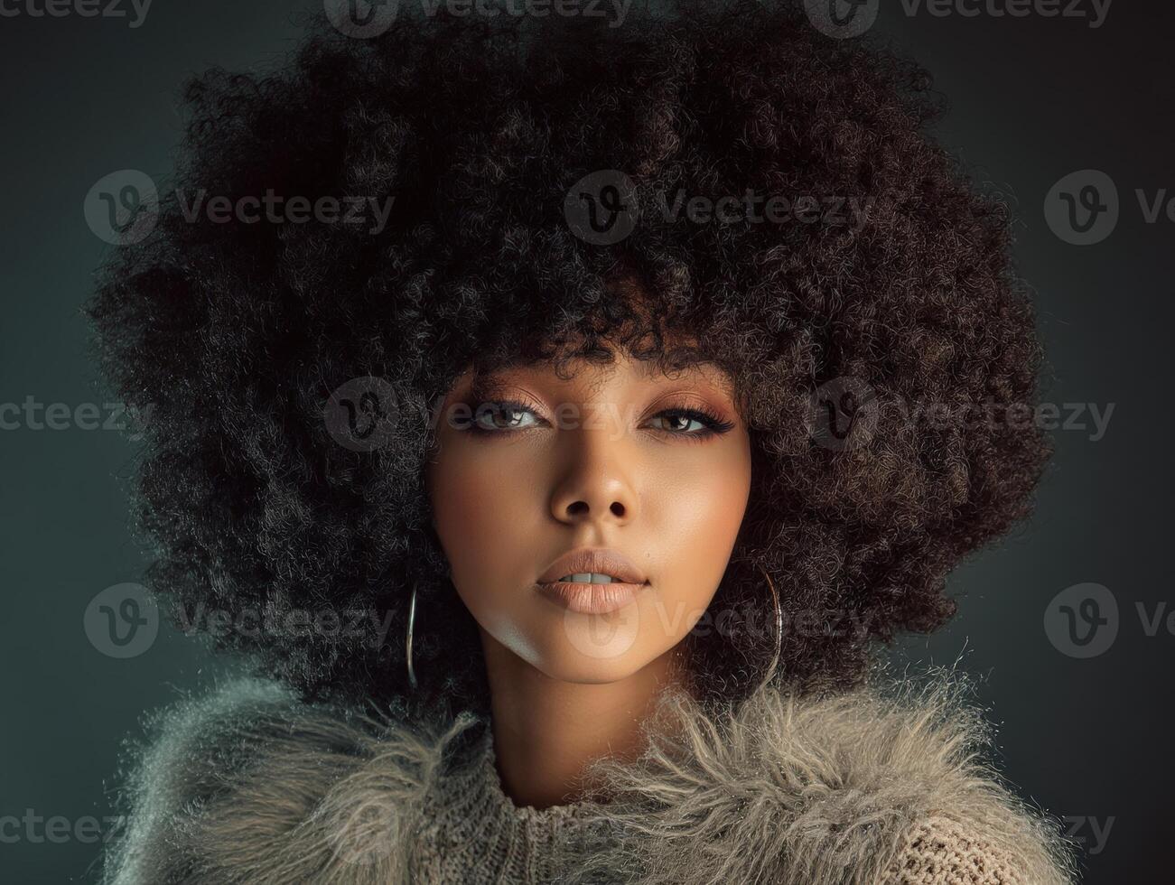 Young woman with voluminous curly hairstyle wearing large hoop earrings and a textured sweater, looking directly at the camera with an elegant expression, soft lighting photo