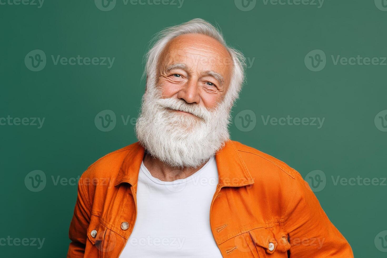 Elderly man with a white beard and smiling expression wearing an orange jacket over a white shirt. His eyes are warm and kind, exuding wisdom. He looks friendly and approachable photo