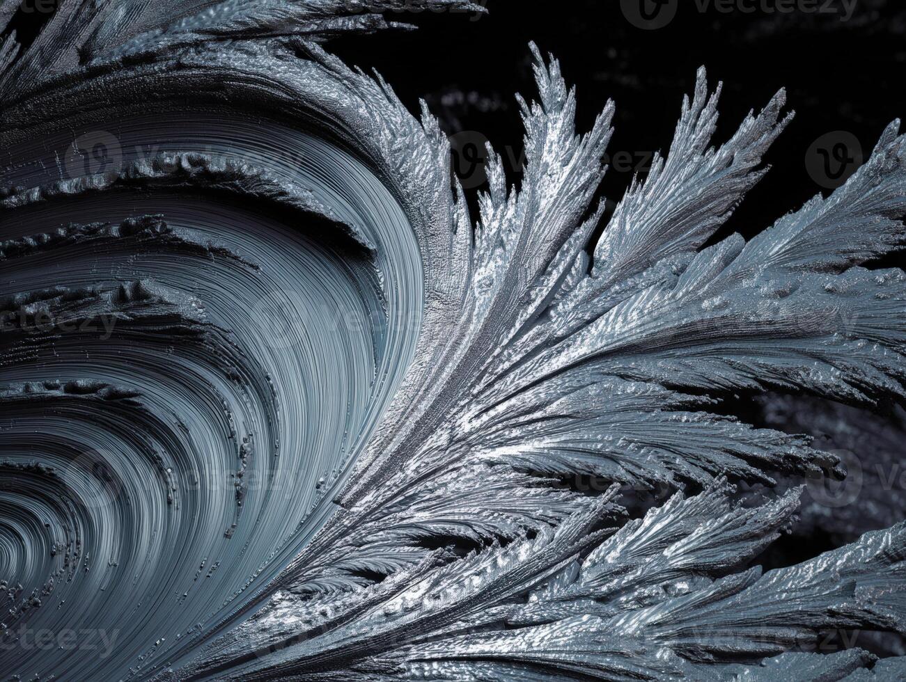 Intricate frost patterns form a swirling, icy design resembling delicate, silvery feathers. The close-up texture emphasizes the organic, crystalline beauty of winter's artistic touch photo