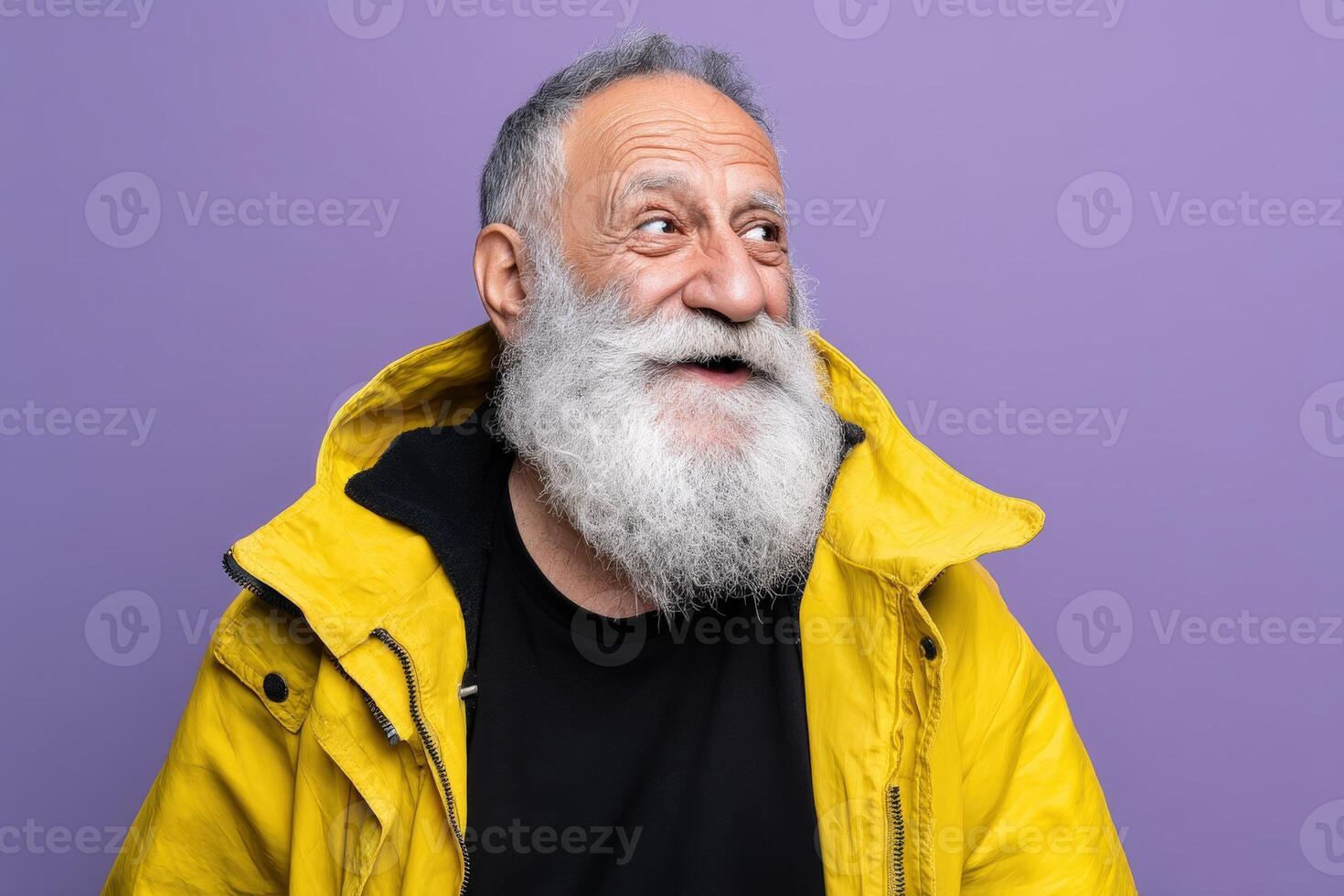 Elderly man with gray beard, wearing a yellow jacket over a black shirt, looks to the side with cheerful expression and wrinkles, conveying warmth and wisdom. Background is lavender photo