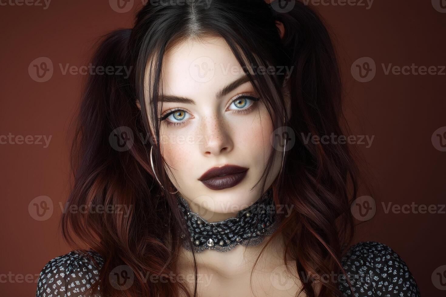 Stylish woman with dark lipstick, piercing blue eyes, wearing a patterned choker and a dress with sheer fabric, highlighted by lighting on her face, accentuating her features photo